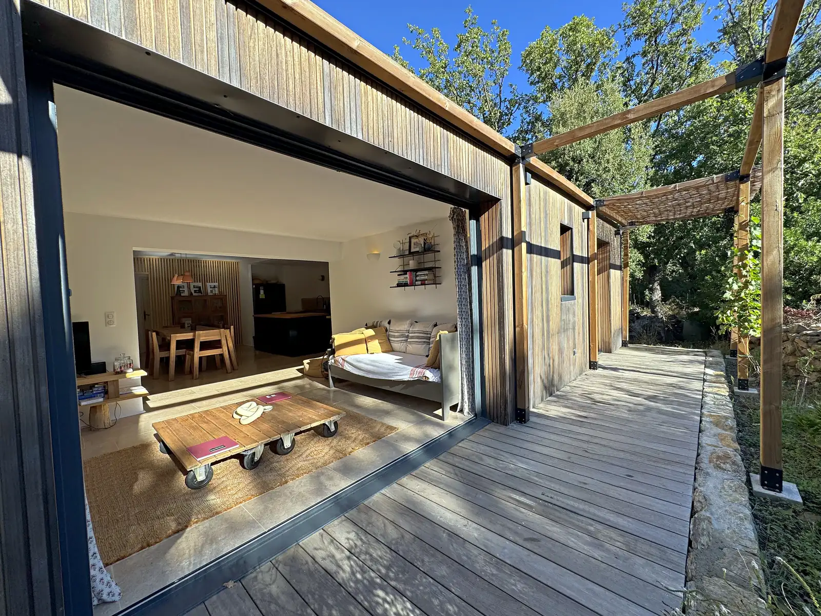 La coursive en bois de Baraccò Argia le long de l'extension contemporaine, sous une pergola de roseaux